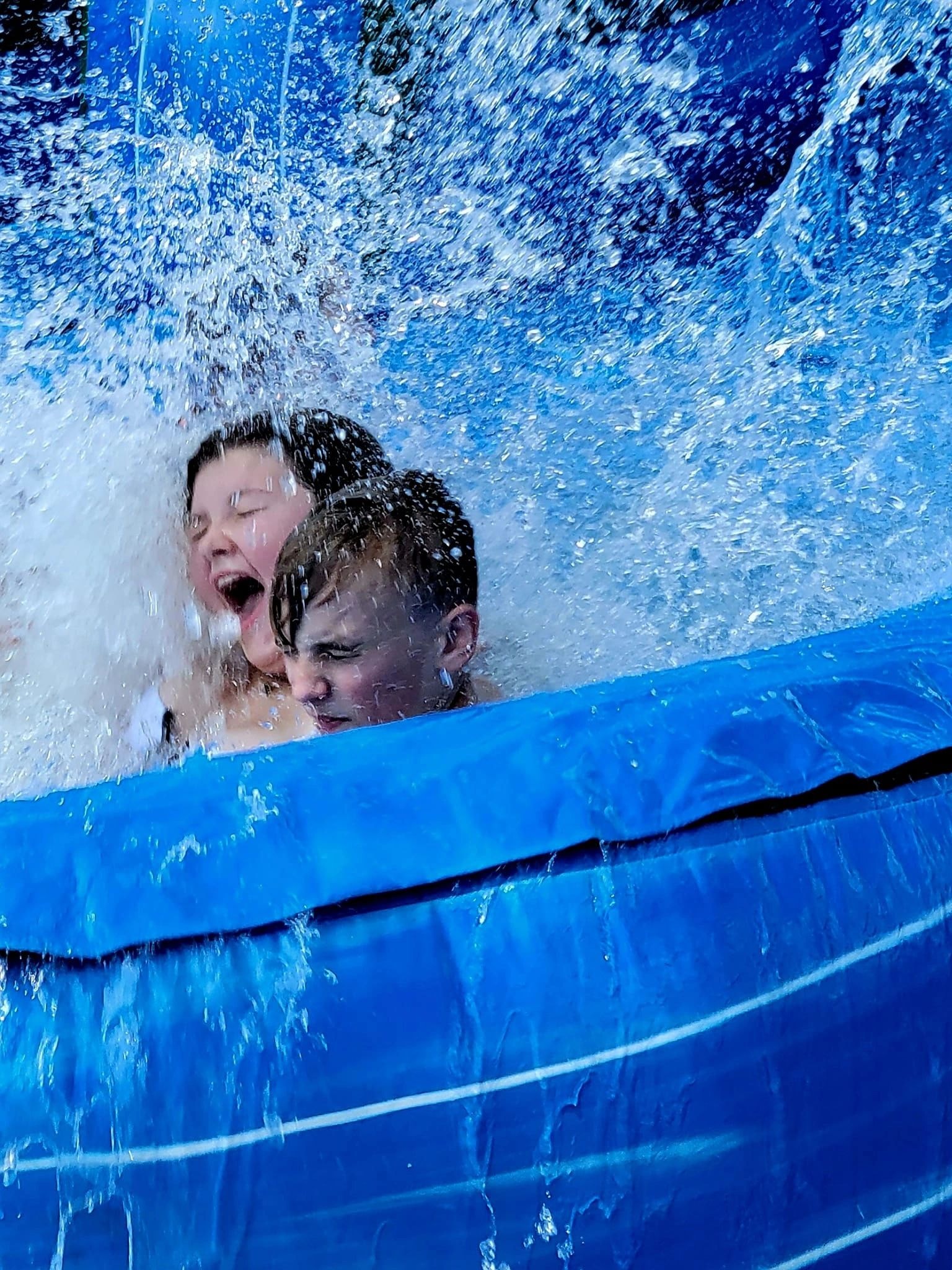 Kids splashing into a pool at an Aloha birthday party by Touches by Jen